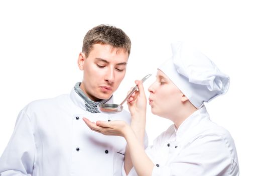 professional chefs try soup from a ladle on a white background