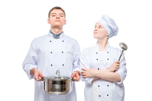 portrait of a man and a woman in cook suits posing with a pan on a white background
