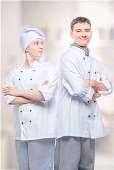 vertical portrait of a successful team of professional chefs in suits against the background of the kitchen