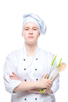 vertical portrait of a young cook with a spoon and culinary tongs isolated on white background