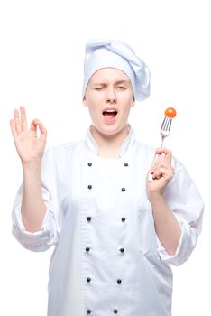 chef in a cap with tomato on a fork shows a hand gesture on a white background