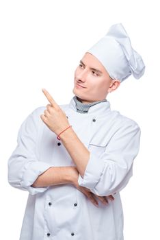 cook in uniform points his finger at something to the side, portrait on white background isolated