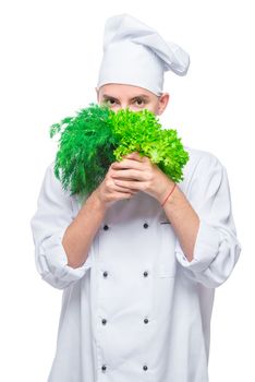 vertical portrait of an experienced chef with fresh greens on a white background