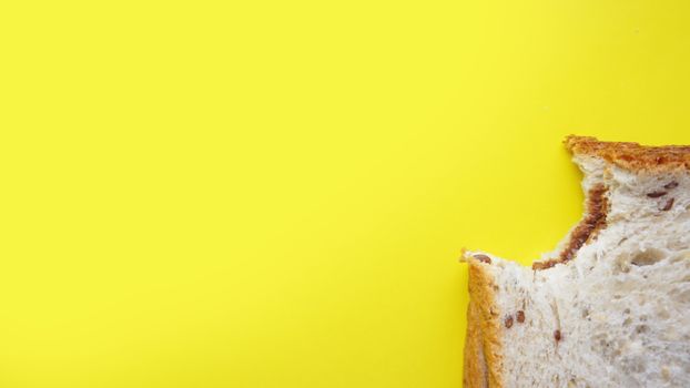 Bitten Toast on yellow background - sandwich with chocolate spread. Background for breakfast. View from above - Copy space photography.