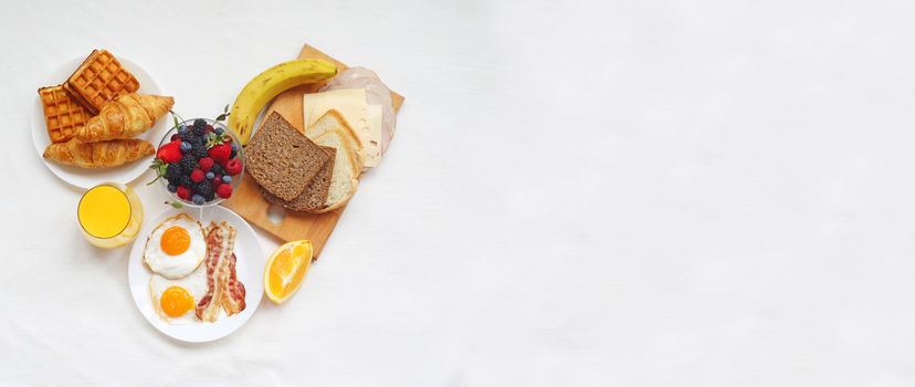 Healthy breakfast with muesli, fruits, berries, nuts, coffee, eggs, honey, oat grains and other on white background. Flat lay, top view, heart shape love concept valentines day