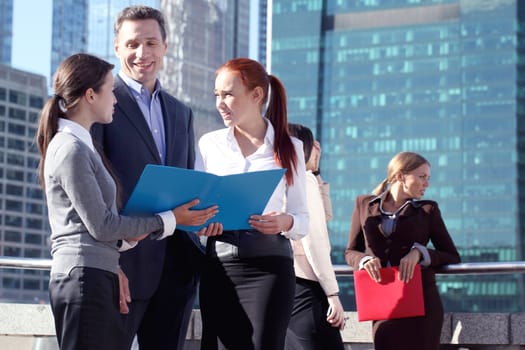 Portrait of business team outside office on skyscrapers background