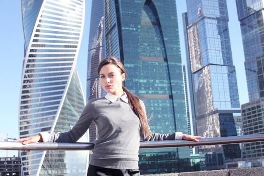 Young beautiful businesswoman outdoors at skyscraper background