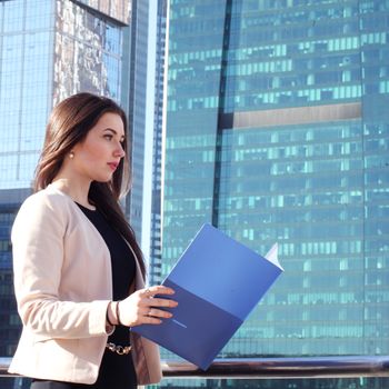 Young beautiful businesswoman outdoors at skyscraper background