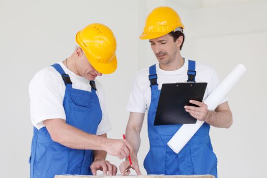 Workers discuss renovation project using digital tablet