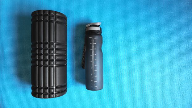 Foam Roller with water bottle Gym Fitness Equipment Blue background self Myofascial Release - MFR.