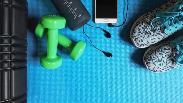 Fitness background. Equipment for gym and home. Blue background top view copy space