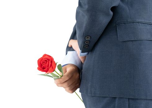 Close up photo of businessman in suit  holding red roses behind his back on white background