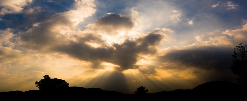 Panoramic sunset with fluffy clouds in the twilight sky,Sunlight with mountain silhouette