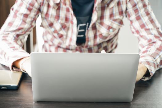 Male hands working with a Laptop computer on the table working at home