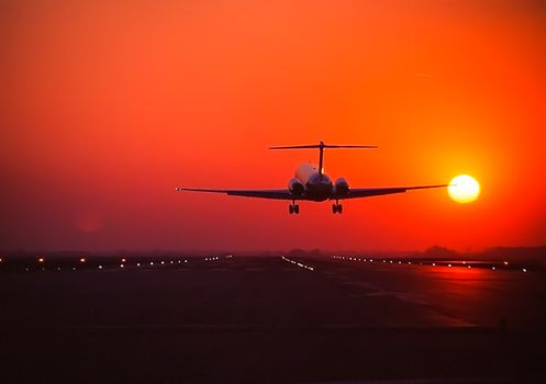 Takeoff of a passenger plane on the background of a sunset. Flight of the air liner at sunset.