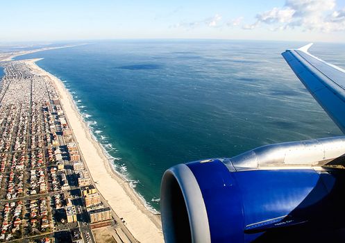 The view from the window of a passenger plane during the flight, the wing of the turbine engine of the aircraft.