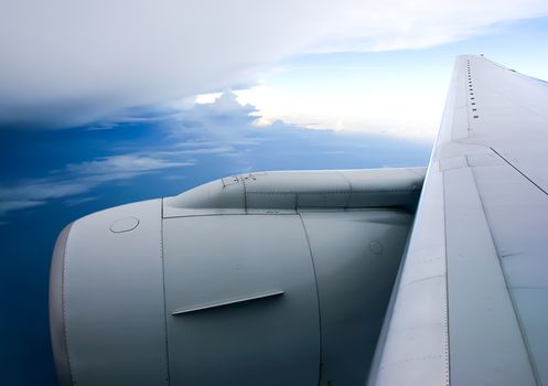 The view from the window of a passenger plane during the flight, the wing of the turbine engine of the aircraft.