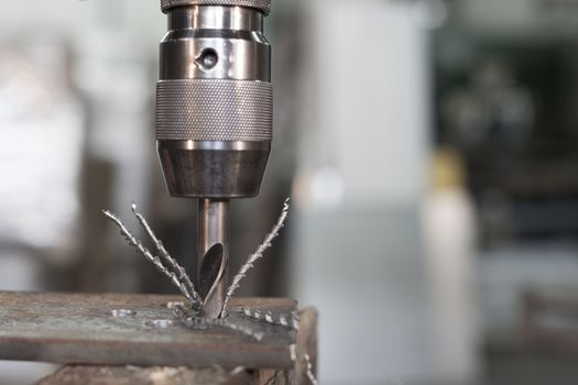Industrial Iron drill in action in steel factory closeup on the drill