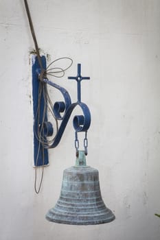 Old church bell on white wall and blue frame