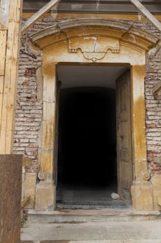 Old church stone doorway with old brown wood dor