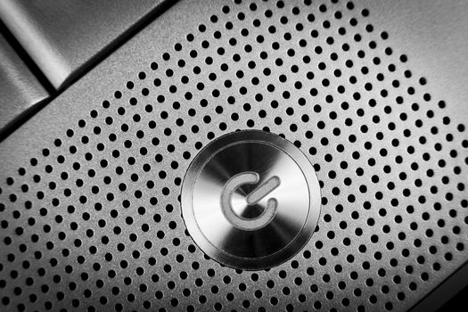 silver color  power button macro closeup  with holes grid arround