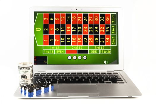 Silver laptop isolated on white background with casino chips and money