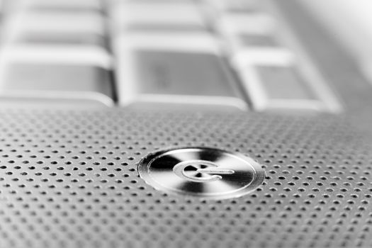 silver color laptop power button macro closeup  with holes grid arround