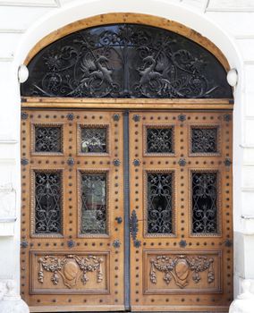 old brows wood entrance door with carving and iron textures