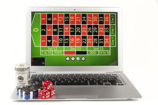 Silver laptop isolated on white background with casino chips red dice and money