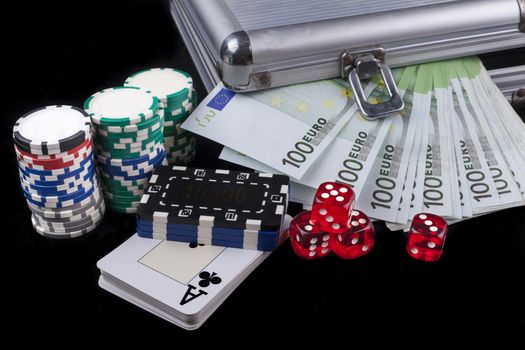 Casino chips and cards with red dices and euro banknotes on black background