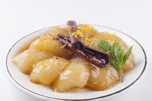 caramelized peras on wite plate with green mint on white background