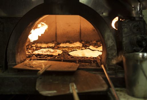 Old style middle east stone oven with flat bread with different spices inside