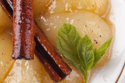 desert plate closeup with caramelized pears and green mint leaves