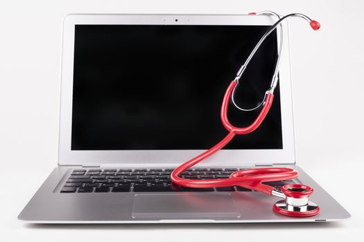 Silver laptop isolated on white background with red stethoscope on it front view