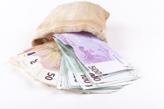 A bag full with euro banknotes pouring out isolated on white background