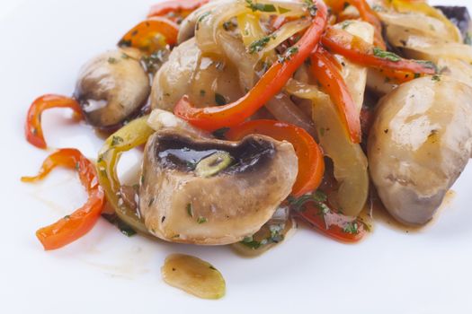 Musrooms and colored vegetables garnish on white plate close-up