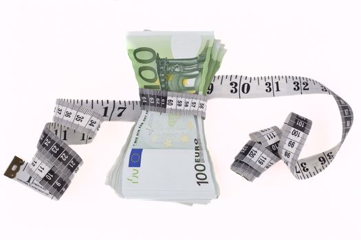 Measuring tape over hundred euro bils isolated on white background