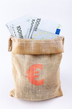 A bag full with 100 euro banknotes with euro sign on the bag isolated on white background