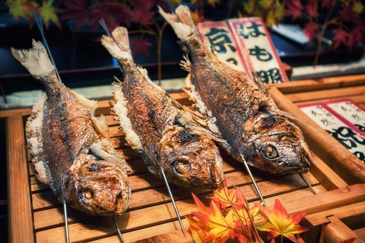 Grilled fishes on sticks as street food at Nishiki market in Kyoto, Japan