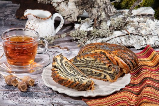 Poppy pastry and a cup of tea on a fabric background