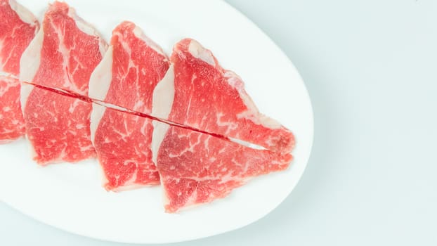 Top view of some raw beef on a plate over white background