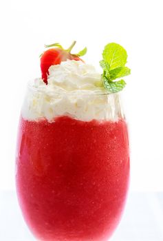 Fresh strawberry smoothie with whipping cream in a glass on the table