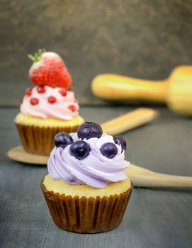 cupcake topped with fresh blueberry and whipped cream