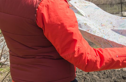 The concept of travel and tourism, location and orienteering. Close-up of a woman looking at a map.