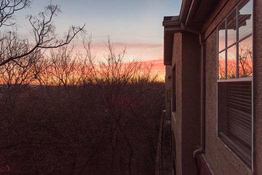 Typical park side apartment complex during winter sunrise with dramatic cloud reflection on windows. Aerial view of apartment building in Texas, America