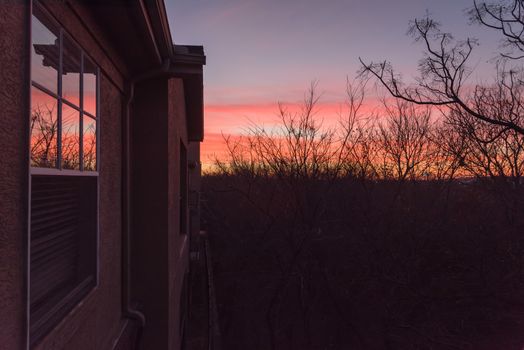 Typical park side apartment complex during winter sunrise with dramatic cloud reflection on windows. Aerial view of apartment building in Texas, America