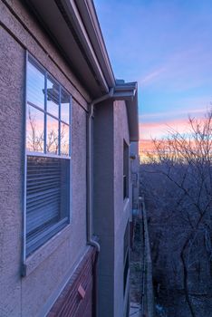 Typical park side apartment complex during winter sunrise with dramatic cloud reflection on windows. Aerial view of apartment building in Texas, America