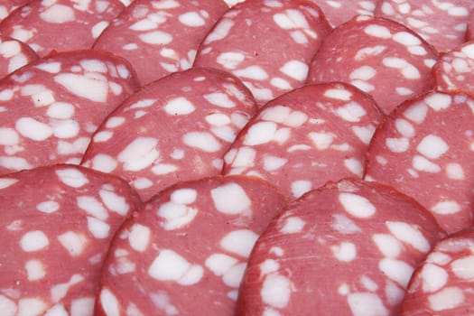 Salami background with many sliced pieces of salami 