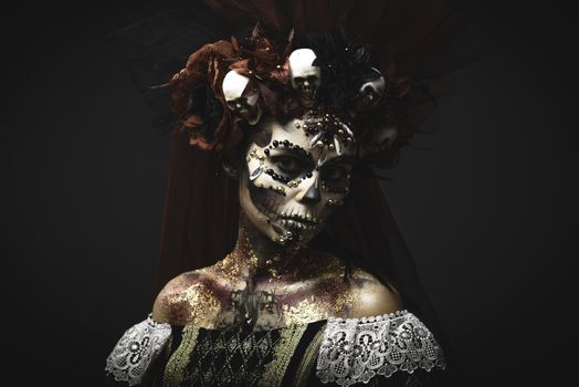 Santa Muerte Young Girl with Artistic Halloween Makeup and with Sculls in her Hair