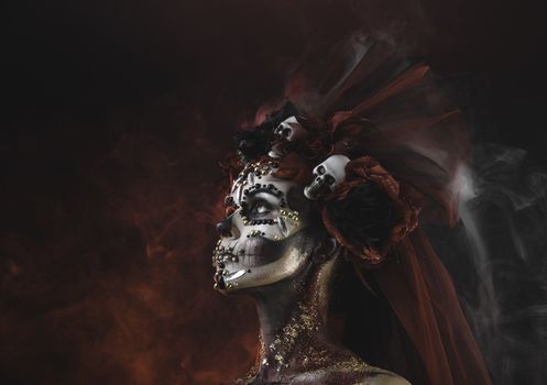 Santa Muerte Young Girl with Artistic Halloween Makeup and with Sculls in her Hair